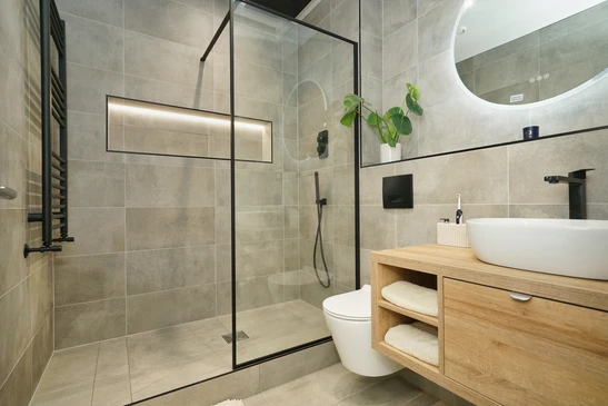 Salle de bain moderne luxueuse avec douche à l'italienne vitrée, baignoire d'angle encastrée, double vasque sur meuble suspendu blanc